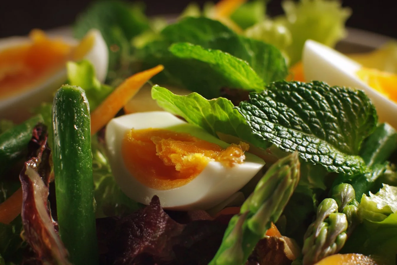 Colorful spring salad with fresh greens and vegetables on a white plate