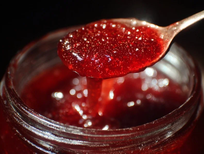 Homemade Strawberry Rhubarb Jam in a jar with fresh strawberries and rhubarb