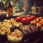 Delicious summer BBQ food displayed on a picnic table with colorful side dishes.