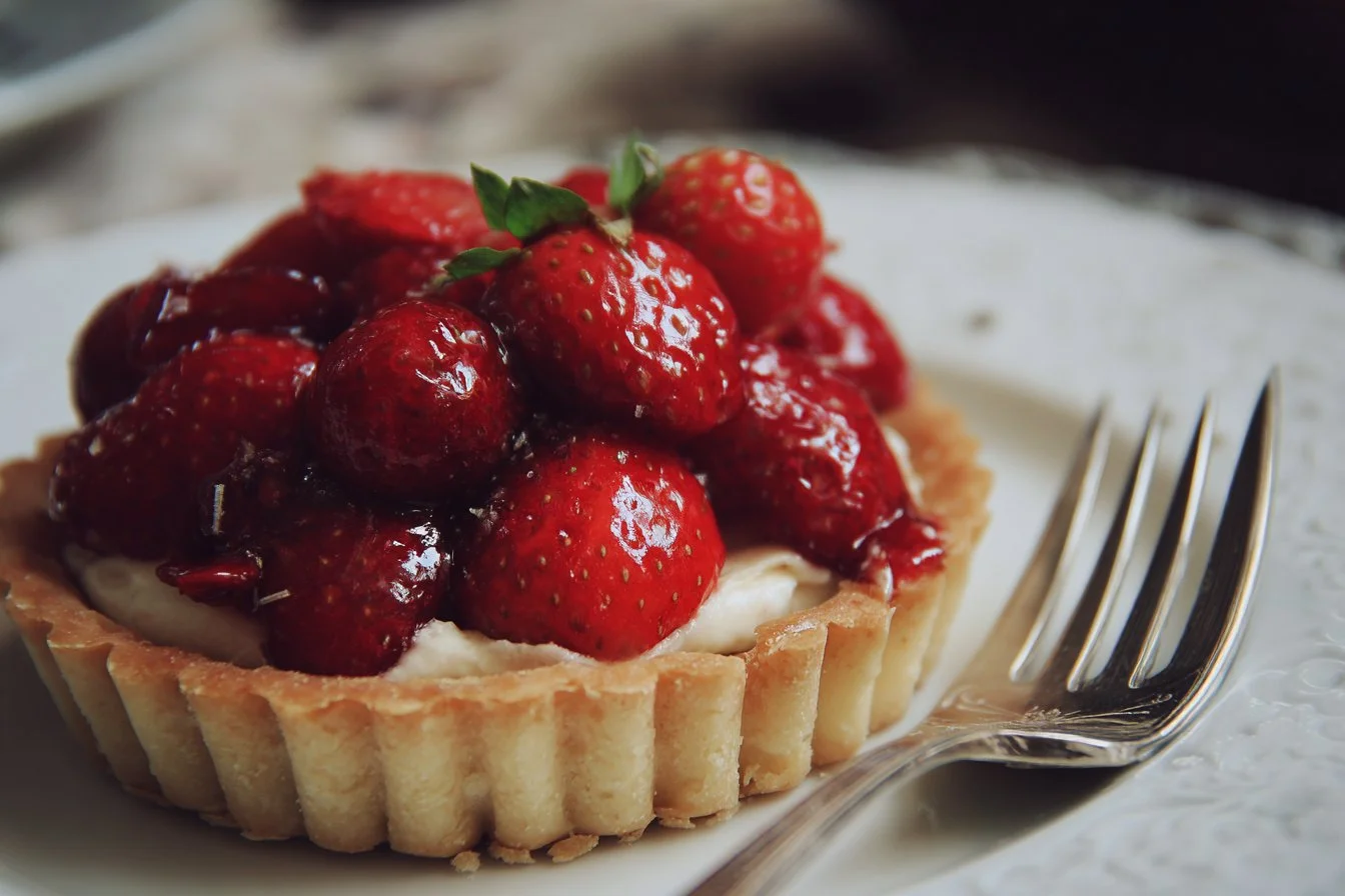 A variety of colorful summer desserts including fruit tarts and ice cream