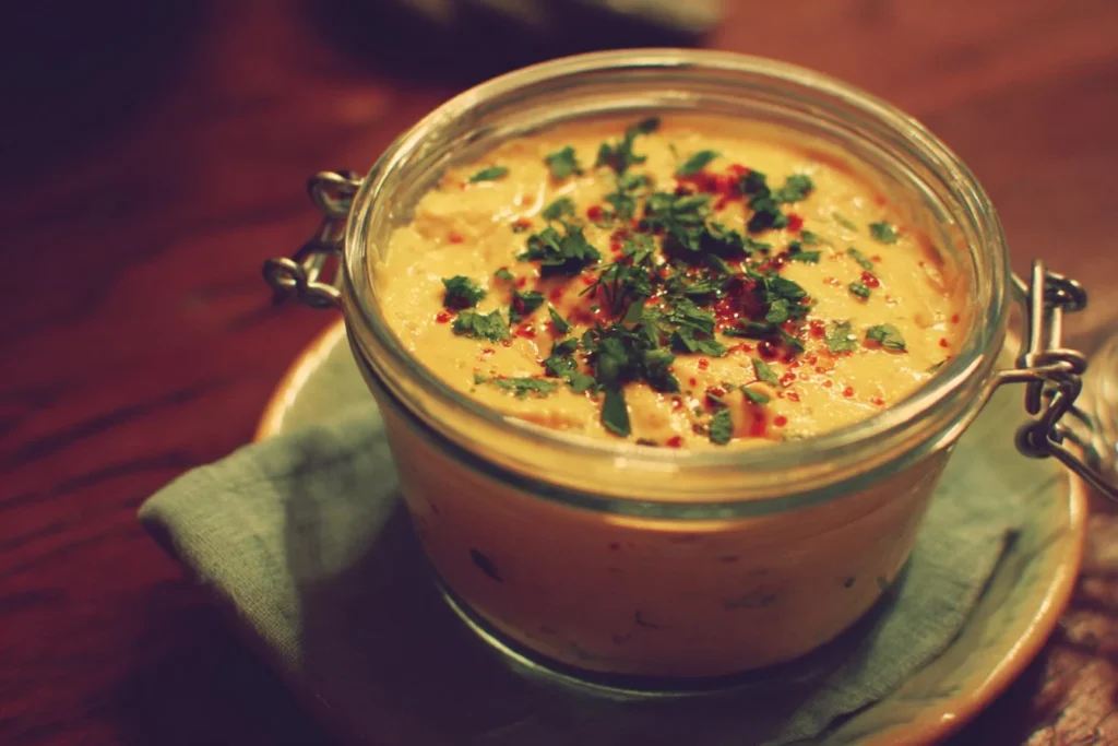 A variety of colorful summer dips served in bowls for a sunny outdoor gathering.