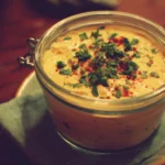 A variety of colorful summer dips served in bowls for a sunny outdoor gathering.