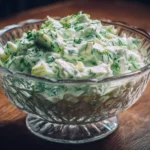 A bowl of Watergate Salad with green color and fruit garnishes