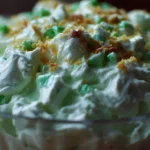 A bowl of colorful Watergate Salad with marshmallows, pineapple, and green pistachio pudding