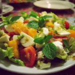 Colorful winter salad with kale, nuts, and seasonal fruits in a bowl.