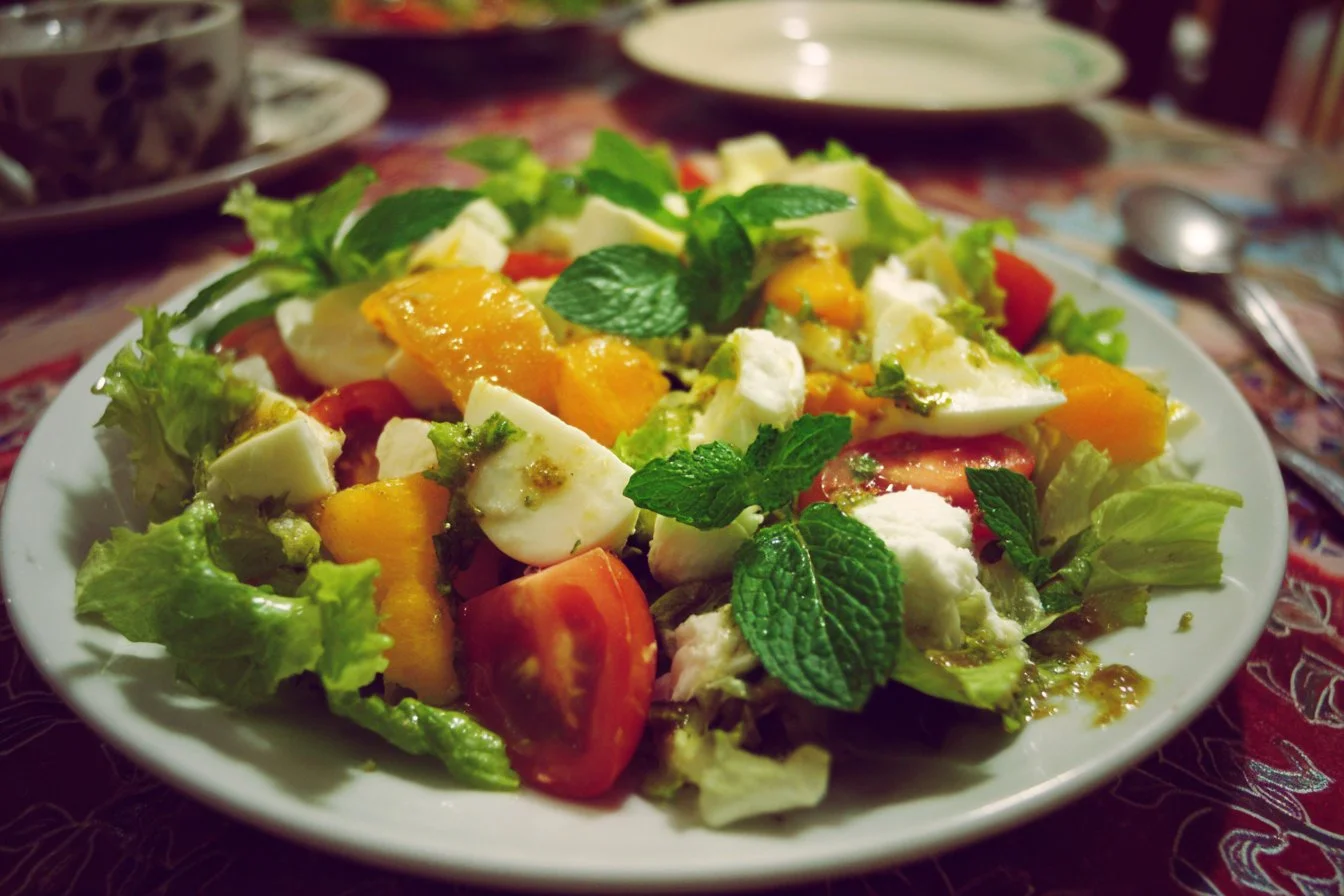 Colorful winter salad with kale, nuts, and seasonal fruits in a bowl.