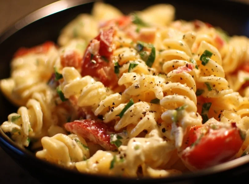 Bowl of easy cold pasta salad with vegetables and dressing.