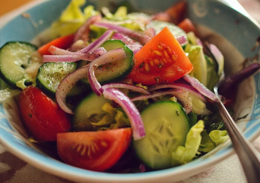 A colorful and fresh easy salad with mixed greens, tomatoes, and cucumbers.