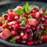 Colorful pomegranate salad with fresh greens and dressing
