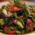 Colorful and fresh Thai Salad with vegetables and herbs on a plate.