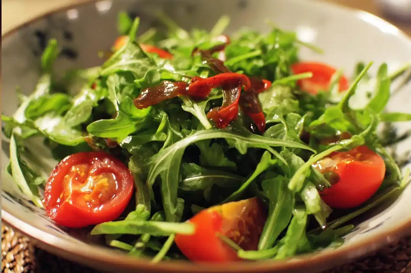 Fresh and vibrant arugula salad with colorful vegetables and dressing