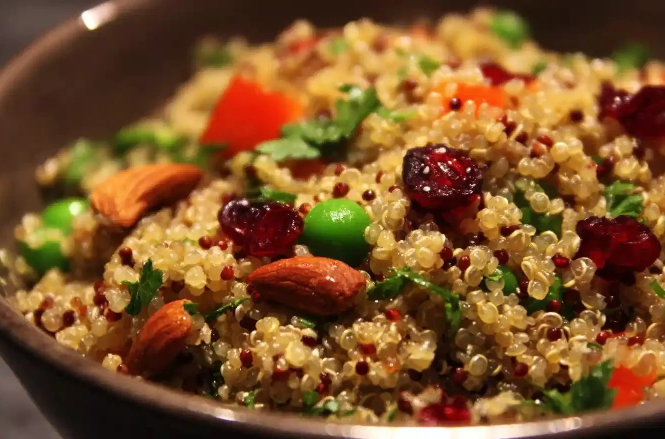 Colorful quinoa salad with vegetables and dressing in a bowl